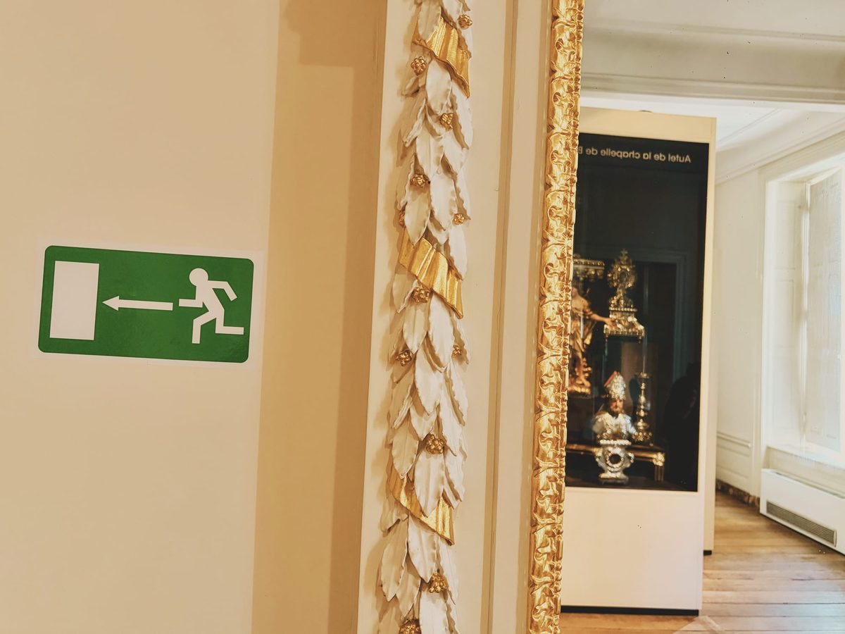 An exit sign juxtaposed with pieces of art in a museum. Image Anthony Nelzin-Santos.