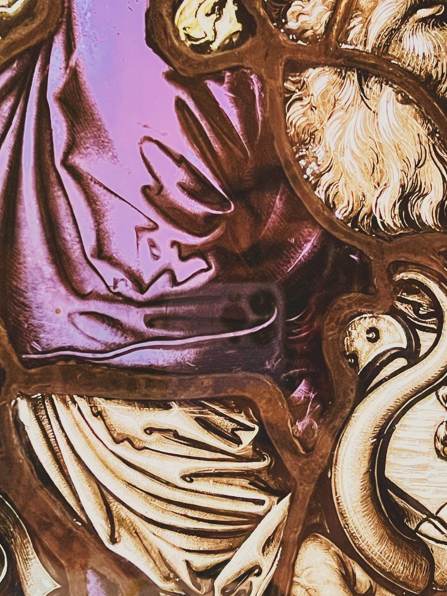 A detail of a purple and white stained glass window. Image Anthony Nelzin-Santos.