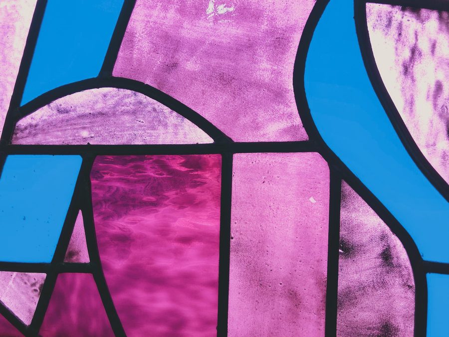 A purple, pink, and blue stained glass window. Image Anthony Nelzin-Santos.